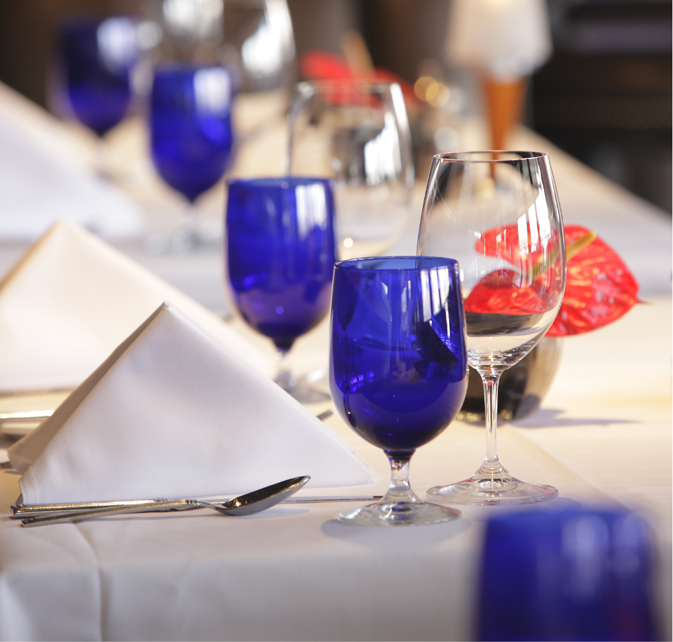 Elegantly set dining table with blue glasses and white napkins at Chandlers